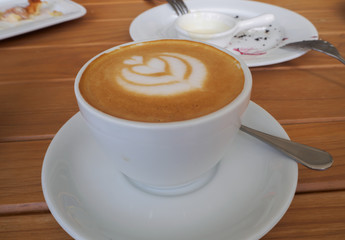 up of Cappuccino Coffee with foam froth cover on top. Cafe shop bokeh background.