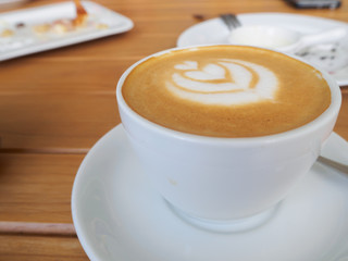 up of Cappuccino Coffee with foam froth cover on top. Cafe shop bokeh background.