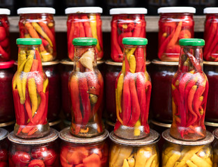 Various canned vegetables, nuts, and mushrooms in the glass jars.