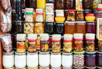 Various canned vegetables, nuts, and mushrooms in the glass jars.