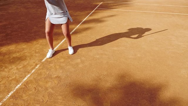 Legs of tennis player on orange clay tennis court during the game