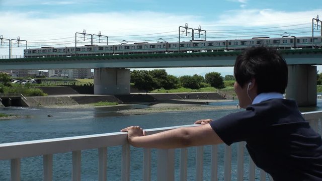 Young JAPANESE RUNNER MAN doing push ups at the riverside of Tama river in Tokyo.
