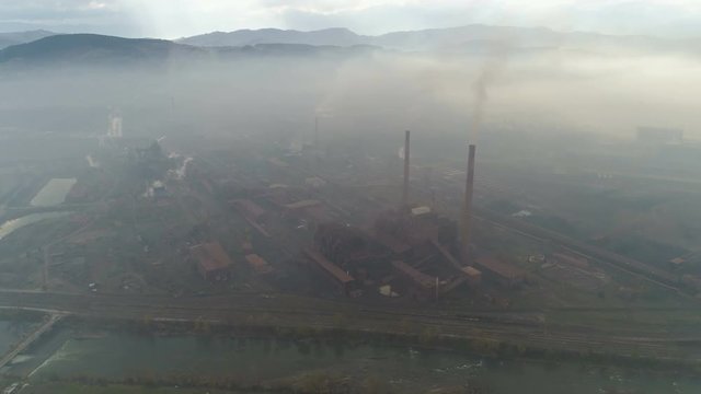 Flying over old rusty steel manufacturing production plant, heavy industry and environmental degradation in Zenica, Bosnia, Europe