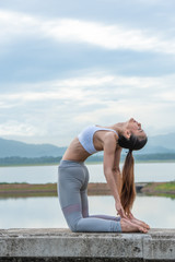 Young healthy woman doing yoga exercises, relax with nature time.