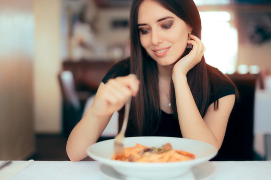 Happy Woman Eating Italian Pasta Course in a Restaurant