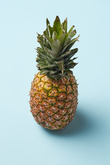 single whole pineapple isolated on blue background