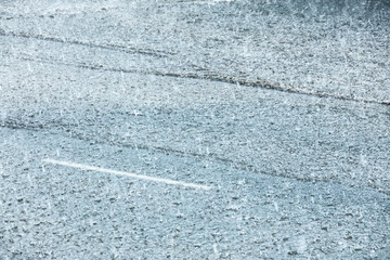 city road flooded during heavy rain. raindrops on water puddles. bad weather