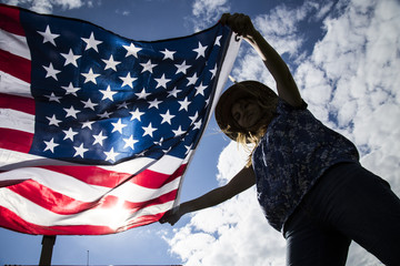 Girl holding the American Flag in windy day