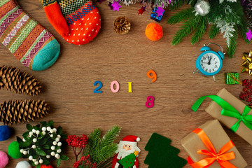 Change of the new year 2018 for the new year 2019. Hours, gifts, spruce cones, Santa Claus, mittens and figures 2018 and 2019 on a wooden background. Meeting the new year.