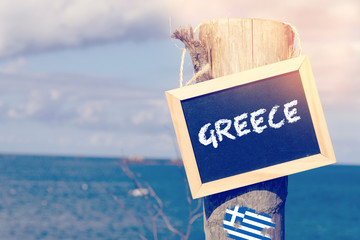 Meer, Strand und eine Kreidetafel mit dem Text Griechenland