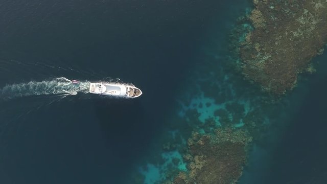Aerial view of boat, passes through to coral reef lagoon - Shaab Rumi