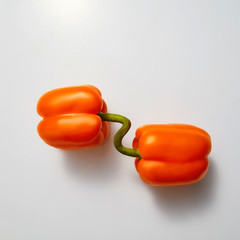 Two ripe orange peppers isolated on a gray background. Healthy Organic Food