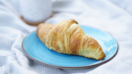 croissants, biscuits and coffee on a picnic overlay