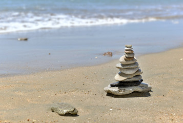 Pebbles piled on the sand in front of the sea 