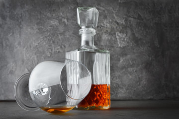 Strong alcoholic drink cognac in lying sniffer glass and crystal decanter