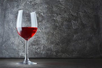 Single glass of red wine for tasting in dark cellar with copy space
