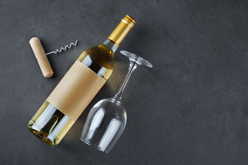Obraz na płótnie Canvas Flat lay of lying white wine bottle with empty label, corkscrew and glass for tasting