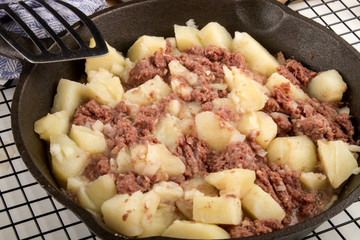 cooked corned beef hash in a cast iron pan