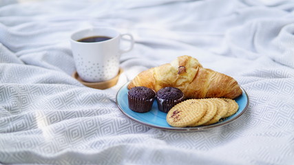croissants, biscuits and coffee on a picnic overlay