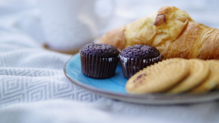 croissants, biscuits and coffee on a picnic overlay
