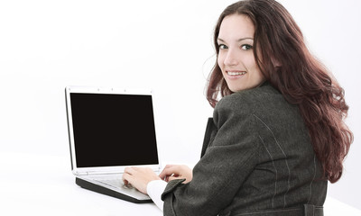 rear view.smiling businesswoman typing on laptop and looking at camera