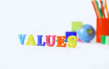 word values on blurred background of school supplies .photo with copy space