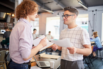 Fototapeta premium Two young economists or managers planning work and discussing new ideas at meeting