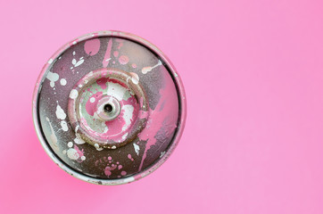 Used spray can with pink paint drips lie on texture background of fashion pastel pink color paper...
