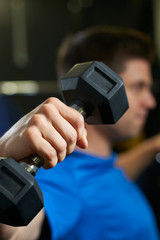 Fototapeta na wymiar Man In Gym Exercising With Weights