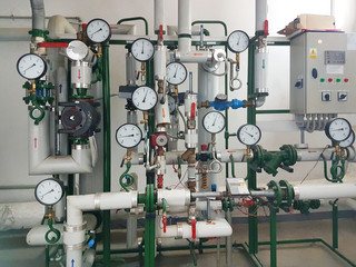 Sensors and devices indicating the parameters of hot water in the heating system of a large house. Interlacing of pipes. Technical training stand. Hydraulic components of the water distribution system