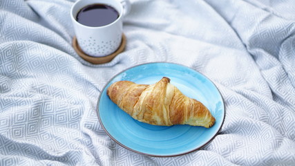 croissants, biscuits and coffee on a picnic overlay