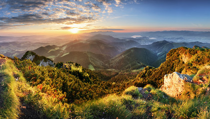 Fototapeta premium Krajobraz górski las pod wieczornym niebie z chmurami w słońcu.