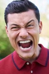 Outdoor Shot Of Angry Young Man Shouting At Camera