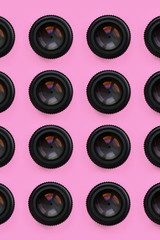 A few camera lenses with a closed aperture lie on texture background of fashion pastel pink color...