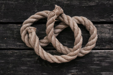 Moorings rope on aged wooden table background.