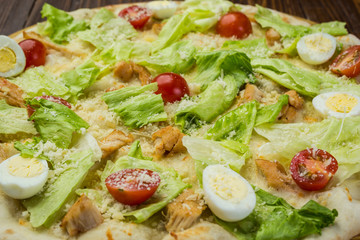 Pizza Caesar with chicken and tomatoes on wooden background