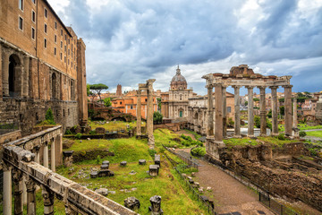 Fototapeta na wymiar View of the temple of Saturn in Roman forum, Italy. Ruins of Septimius Severus Arch and Saturn Temple. Rome architecture and landmark.