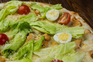 Pizza Caesar with chicken and tomatoes on wooden background