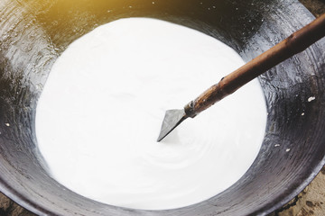 slowly stirring up coconut milk during boiling