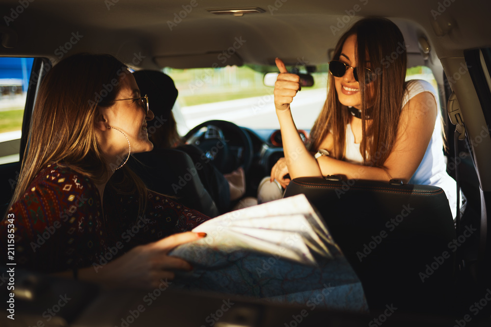 Wall mural Three young women having fun on roadtrip