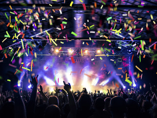Flare, haze and confetti falling on a concert crowd