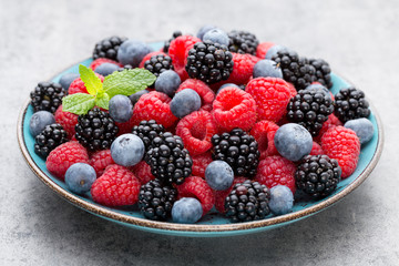 Fresh raspberries in a plate on a  vintage background.