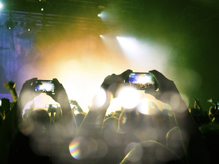 Flare, haze and confetti falling on a concert crowd
