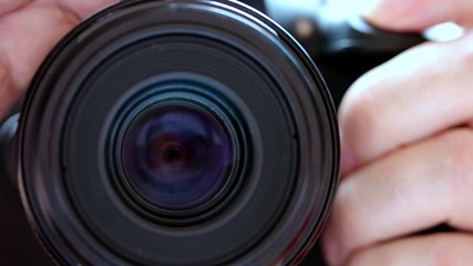 Slowly press the shutter release button, close up. The front view to lens of camera with take photo.