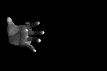 Hand of woman reaching out from the dark