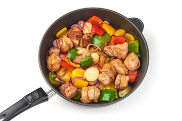 Pieces of grilled barbecue with vegetables on frying pan, isolated on white background.