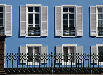 Window shutters opened against  blue wall
