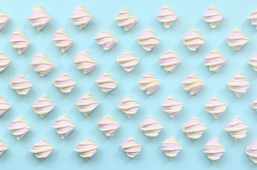 Colorful marshmallow laid out on blue paper background. pastel creative textured pattern. minimal