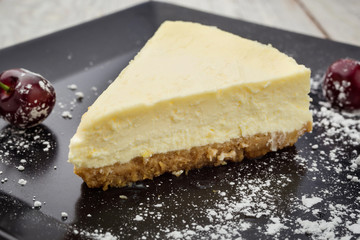Classic New York cheesecake with berries on black plate. Dessert concept