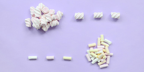 Colorful marshmallow laid out on violet paper background. pastel creative texture. minimal